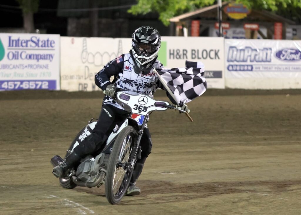 Mike Newnham takes a turn with the checkered flag after winning the Support D2 division main event. July 10 2026 - 2026 Speedway & Team Challenge Round #4.